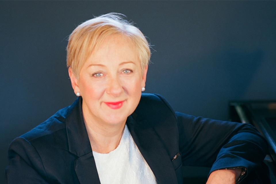 A woman with blonde hair smiling into the camera